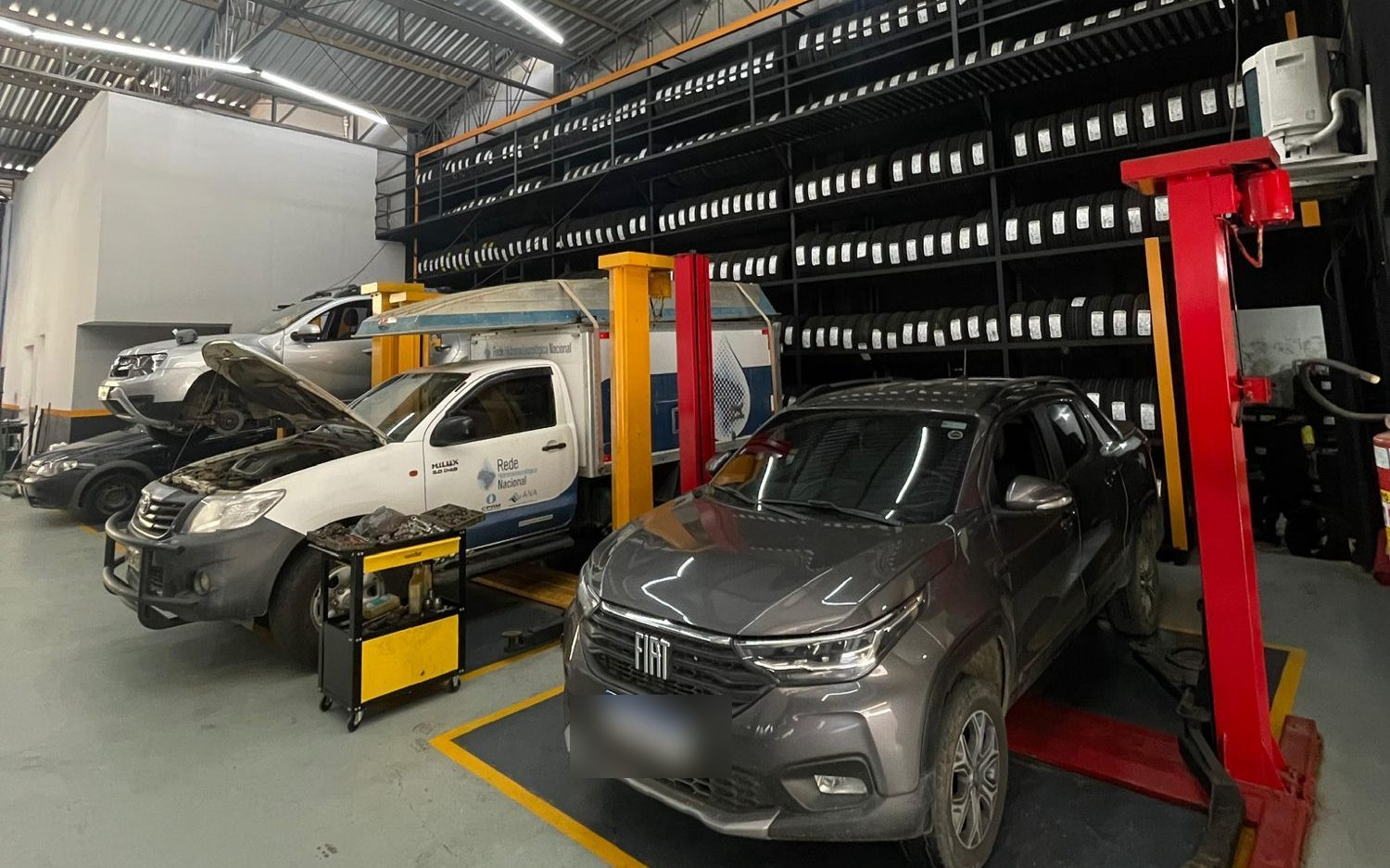 Pátio de serviço da Chaim Pneus com elevadores e estoque de pneus